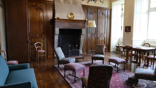 Salon avec cheminée, chandelier et mobilier ancien au château de Cerisy La Salle