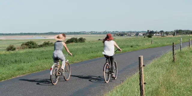 Deux personnes à vélo roulant sur une route de campagne