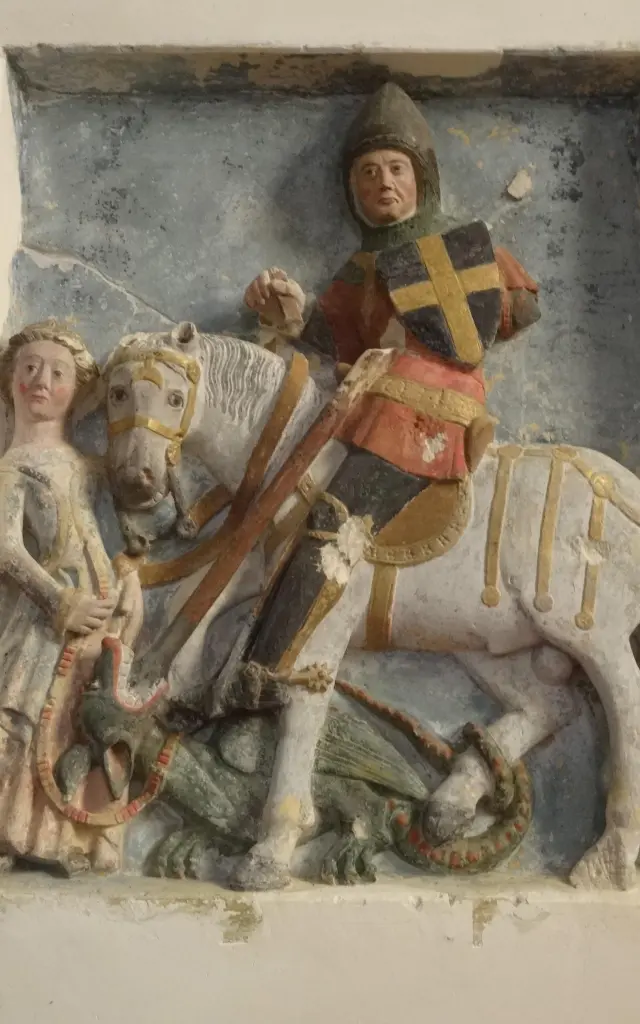Statue d'un chevalier en armure sur un cheval blanc terrassant un dragon dans l'église de Montchaton