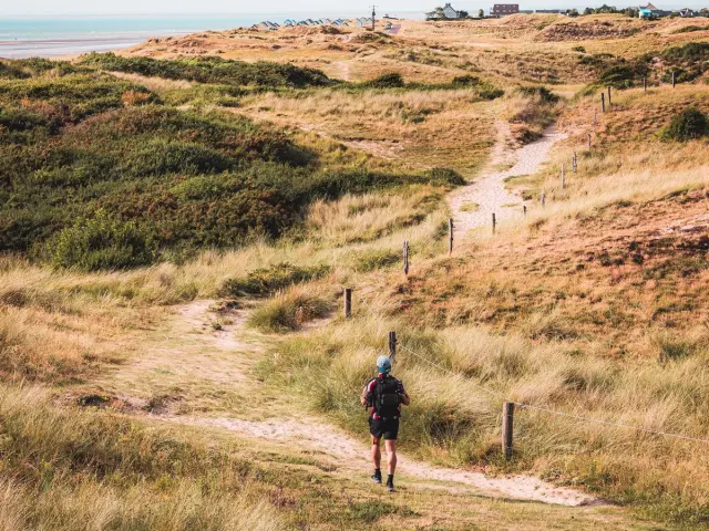 Personne marchant sur un sentier dans les dunes près de la mer à Blainville-sur-Mer