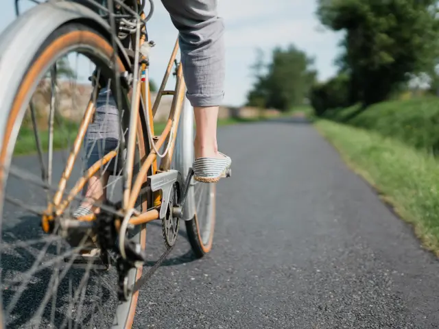 Pieds d'un cycliste en mouvement sur une route de campagne