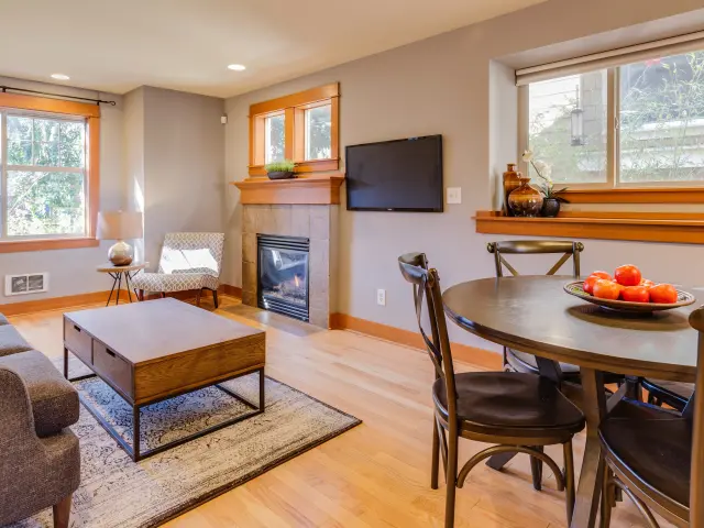 Salon moderne avec cheminée, télévision et table à manger