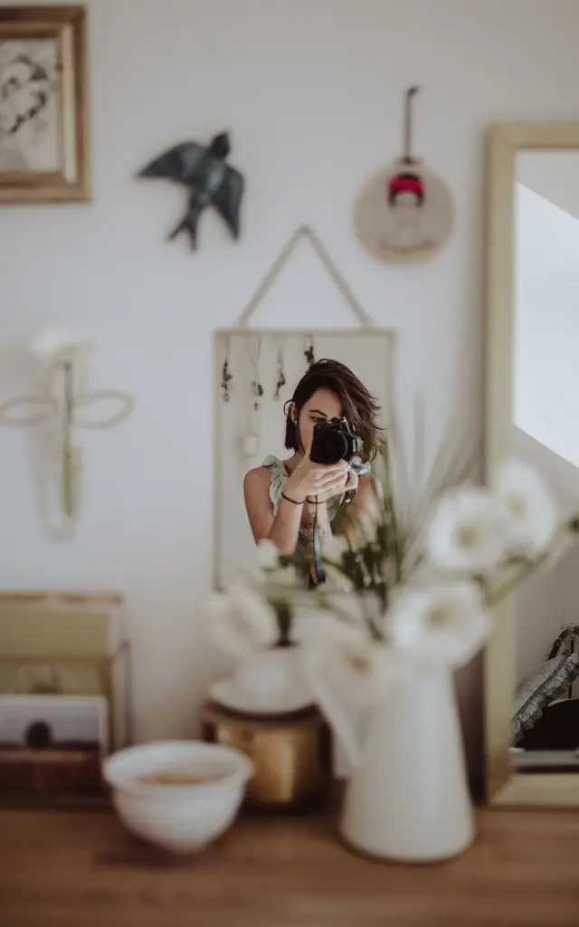 Femme prenant une photo avec un appareil photo dans un intérieur décoré