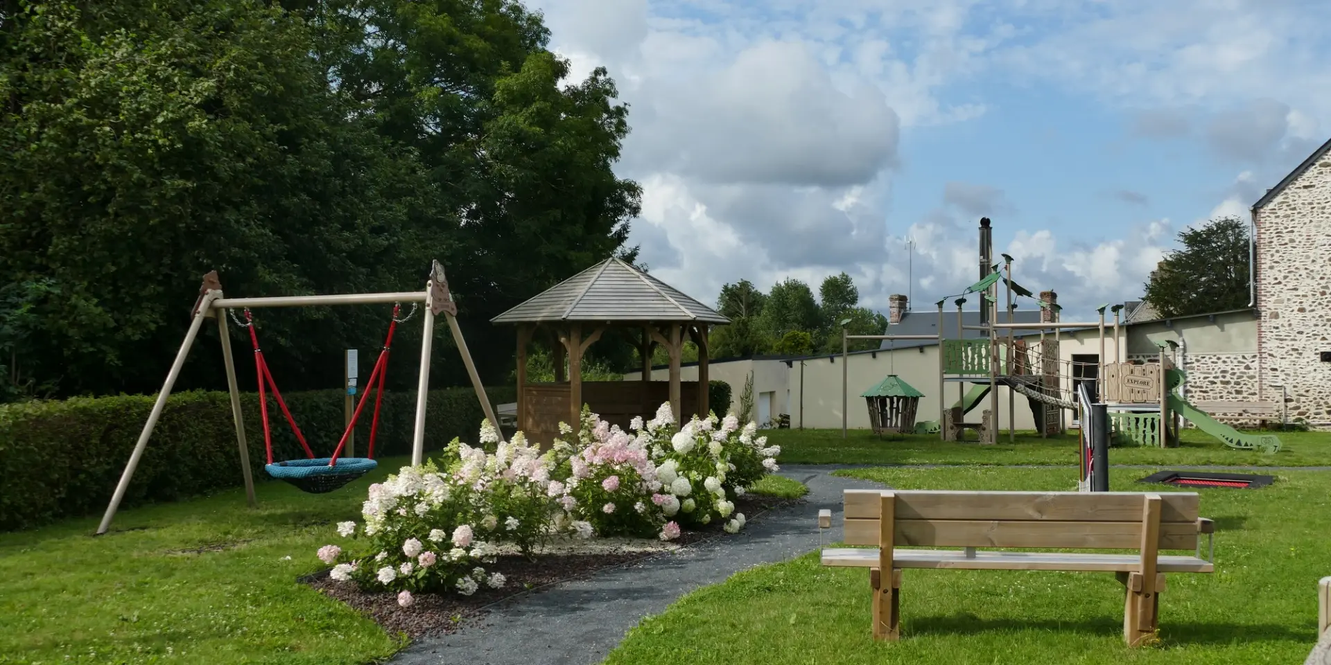 Aire de jeux avec balançoire, banc et structure à Courcy