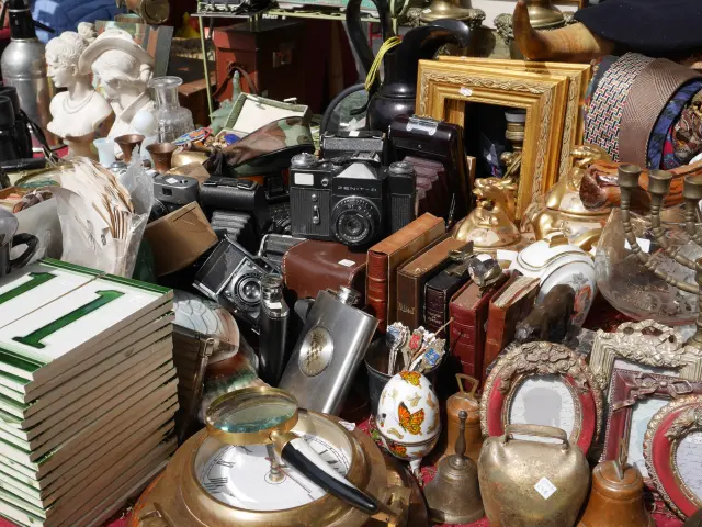 Intérieur d'une boutique d'antiquités remplie de meubles anciens, de lampes, de vaisselle et d'objets décoratifs