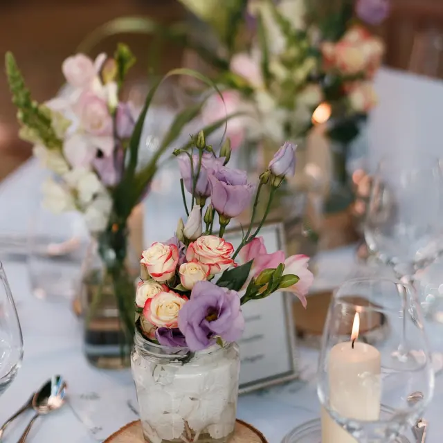 Table décorée avec des vases de fleurs et des bougies