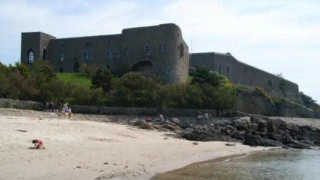 Steinschloss auf einem Hügel über einem Sandstrand
