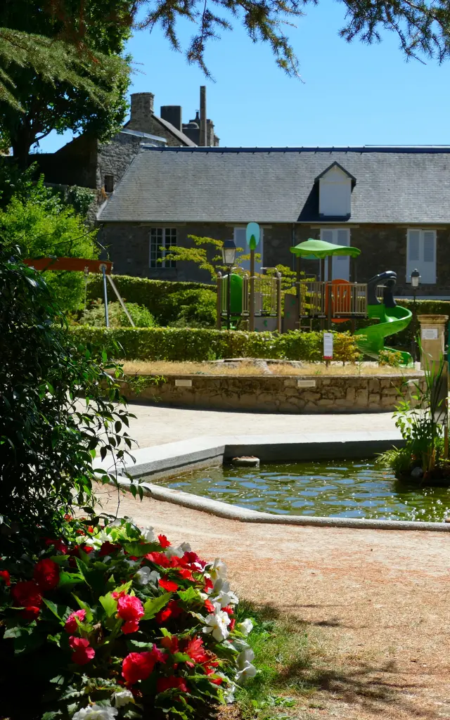 Jardin des plantes de Coutancesavec une fontaine centrale et des jeux pour enfants en arrière-plan