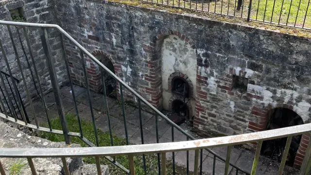 View of a ruined old bread oven surrounded by a metal fence