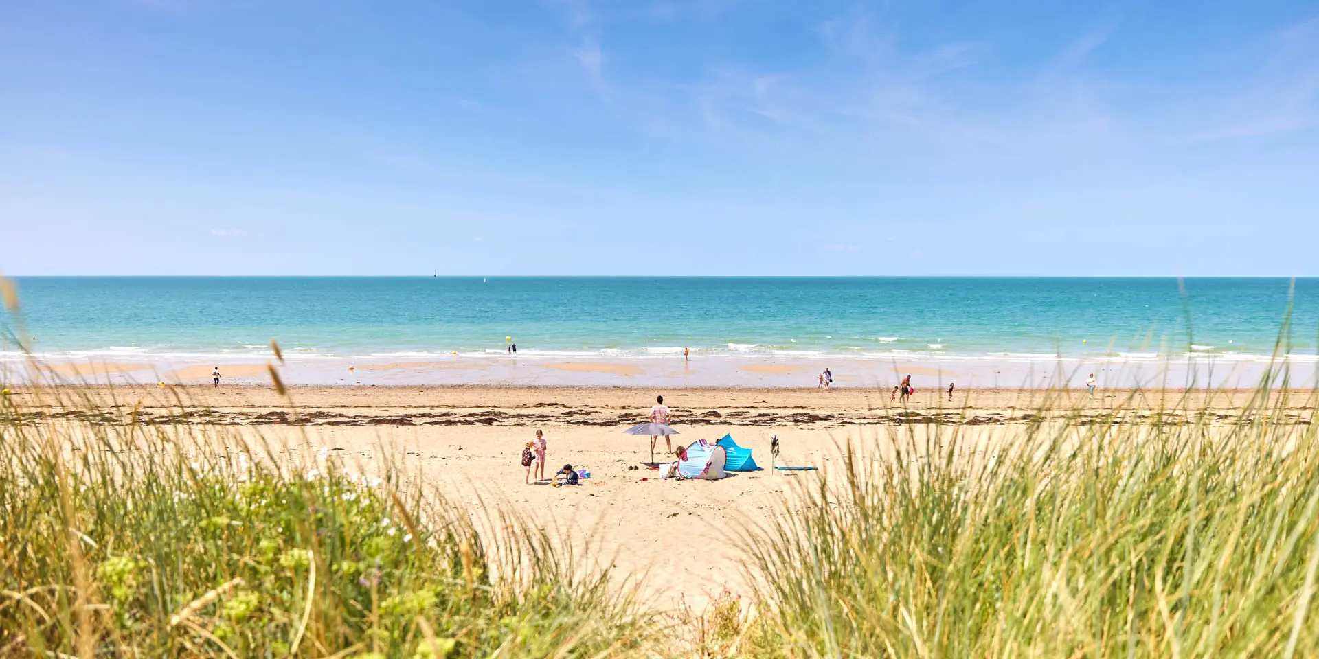 Menschen genießen einen sonnigen Tag an einem Sandstrand