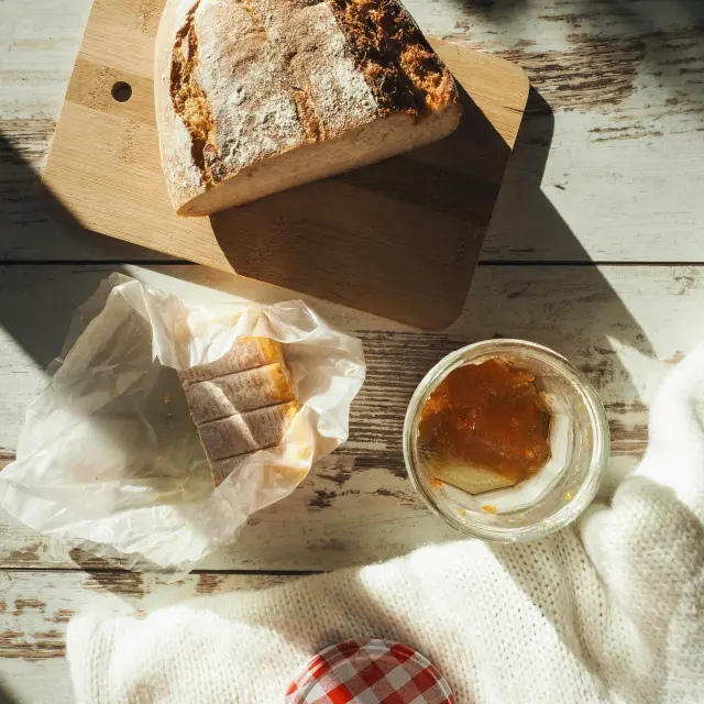 Cardboard plate with two slices of cake and a wooden fork, alongside a cup of coffee
