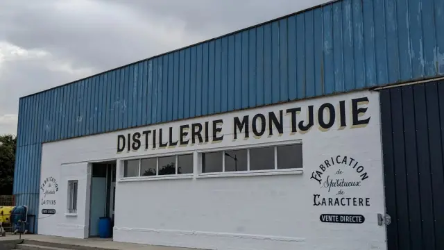 Bâtiment industriel de la distillerie Montjoie avec logo et texte en français
