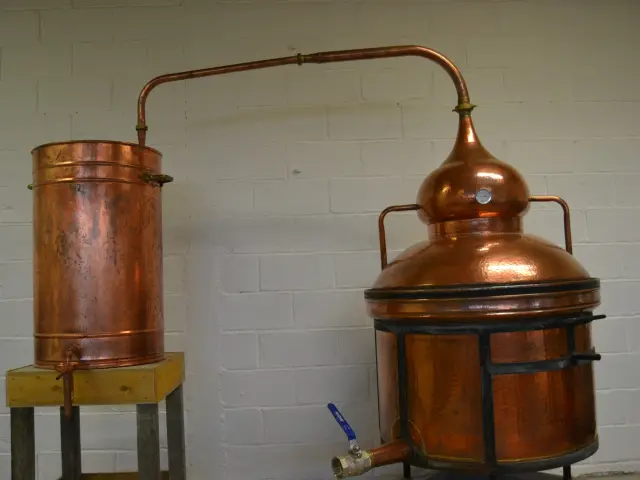 Alambic en cuivre avec un récipient de collecte à la distillerie Montjoie de Gavray