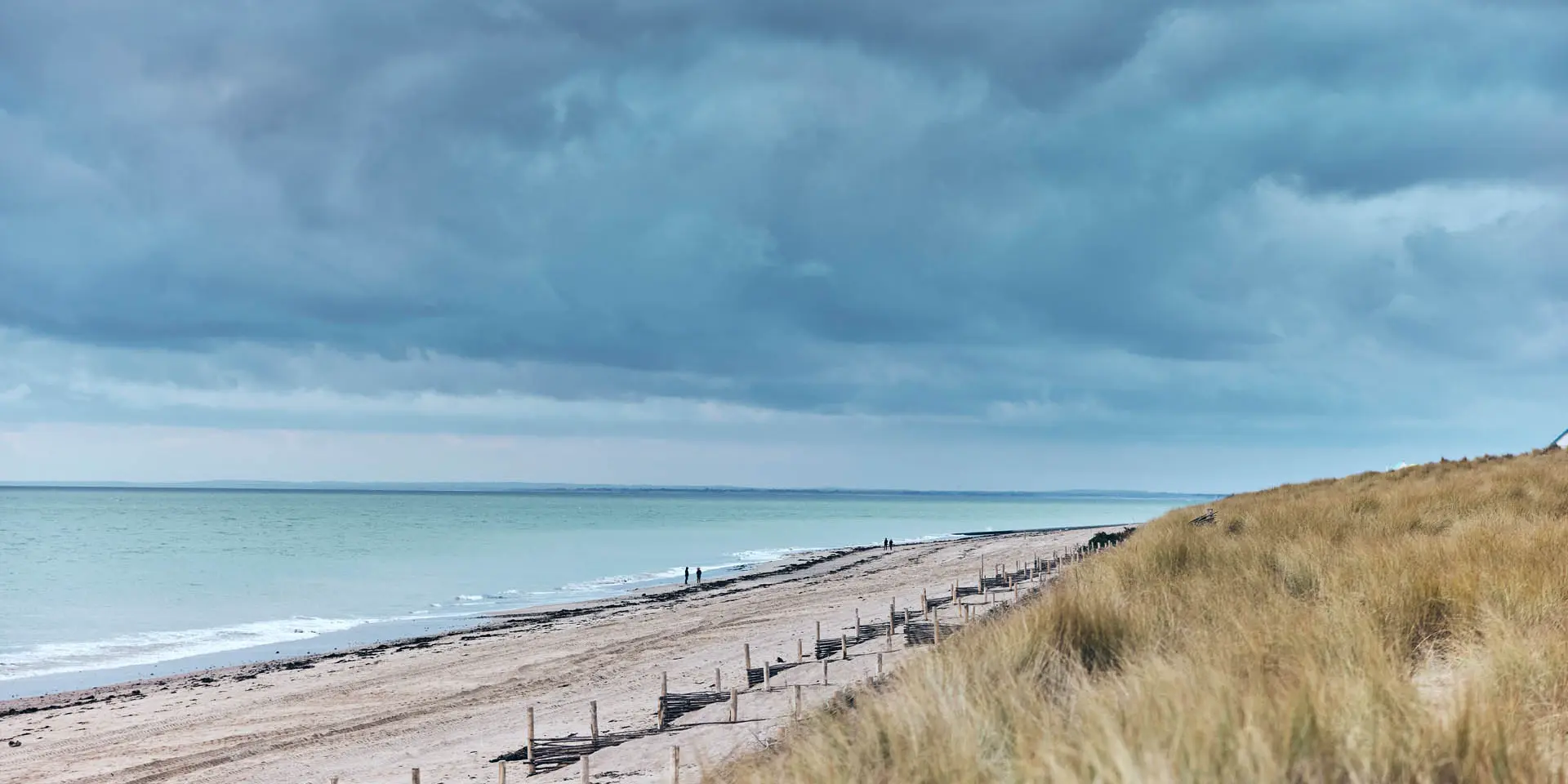 Sandstrand mit dunklen Wolken darüber