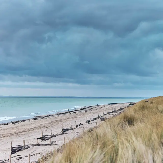 Sandstrand mit dunklen Wolken darüber