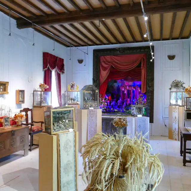 Salon de thé avec tables en bois, chaises rembourrées et vitrines exposant des pâtisseries