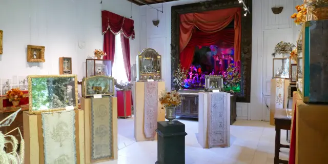 Salon de thé avec tables en bois, chaises en velours rouge et décor floral