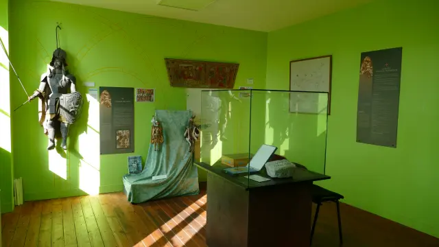 Salon vert avec un canapé, une table basse, une statue, des cadres muraux et des plantes