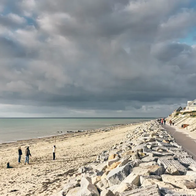 Sandstrand mit Felsen und einem Küstenweg