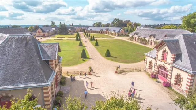 Jardins en terrasses avec des allées sinueuses, des bâtiments en pierre et des voiliers amarrés à proximité