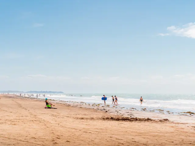 Personnes se promenant et jouant sur une plage de sable à Lingreville