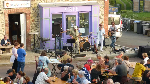 Terrasse de café en bord de port avec des clients attablés et des voiliers amarrés