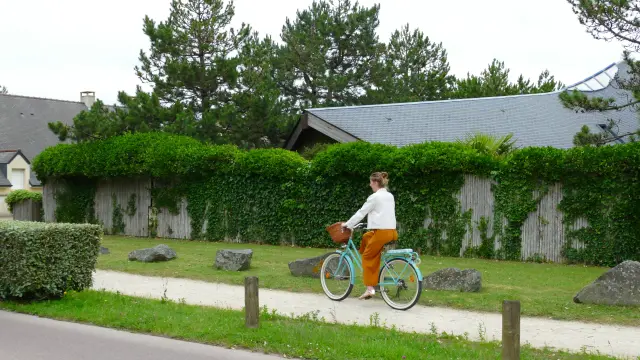 Une personne en orange et blanc fait du vélo sur un espace dédié à Agon-Coutainville