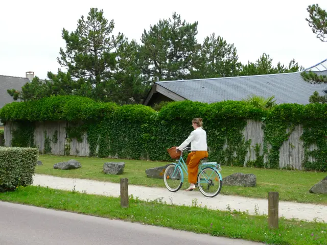 Une personne en orange et blanc fait du vélo sur un espace dédié à Agon-Coutainville