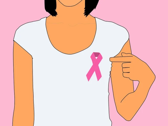 Personne portant un ruban rose sur un t-shirt blanc pour octobre rose
