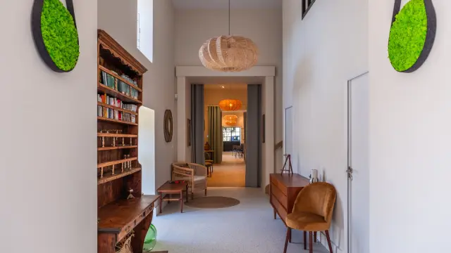 Intérieur moderne avec bibliothèque en bois, chaises en cuir et décorations murales : eco domaine du Plessis