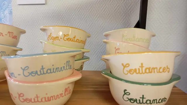 Deux tasses de café en céramique estampillées Coutances posées sur une table en bois