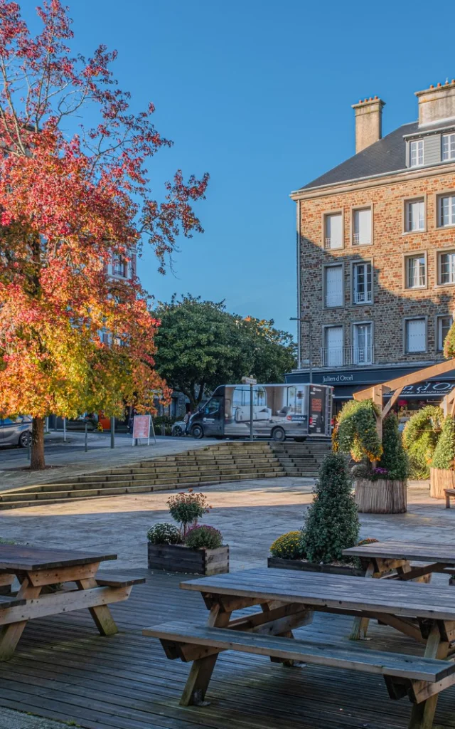 Place Saint-Nicolas avec tables en bois et pergola décorée de plantes, couleurs automnales
