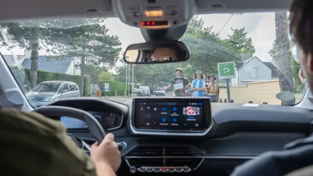 Écran GPS intégré dans une voiture affichant une carte routière avec des icônes de trafic