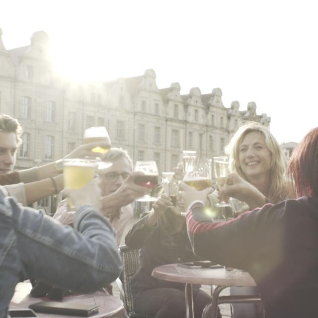 Noordfrankrijk_Arras_Grand Place_ Groupe trinquant en terrasse_Bières © Hauts-de-France Tourisme_Bastien Pradeau