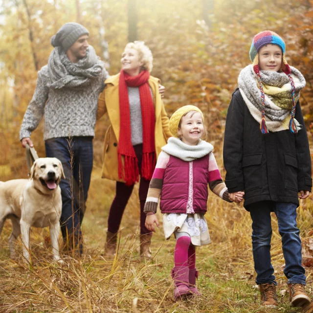 Parents with children walking in autumn woods