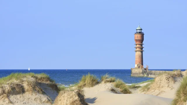 Dunkerque. Le phare Saint Pol au bout de la digue du Break derriere les oyats et les dunes du Break.