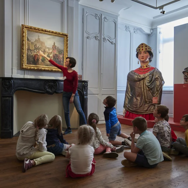 CASSEL (NORD, 59). Musée Départemental de Flandre. Groupe scolaire en visite dans la salle des Géants devant une oeuvre de Alexis BAFCOP (1804-1895) - Le Carnaval de Cassel (1876) - Legs de l'artiste, 1895.