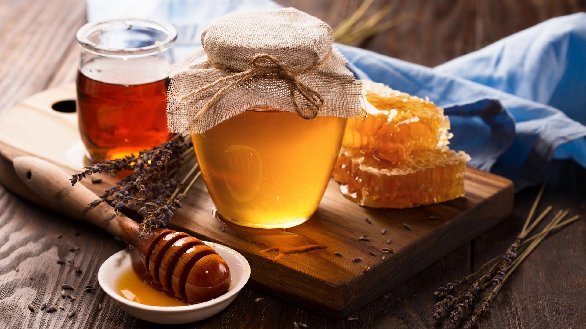 Honey in jar and bunch of dry lavender