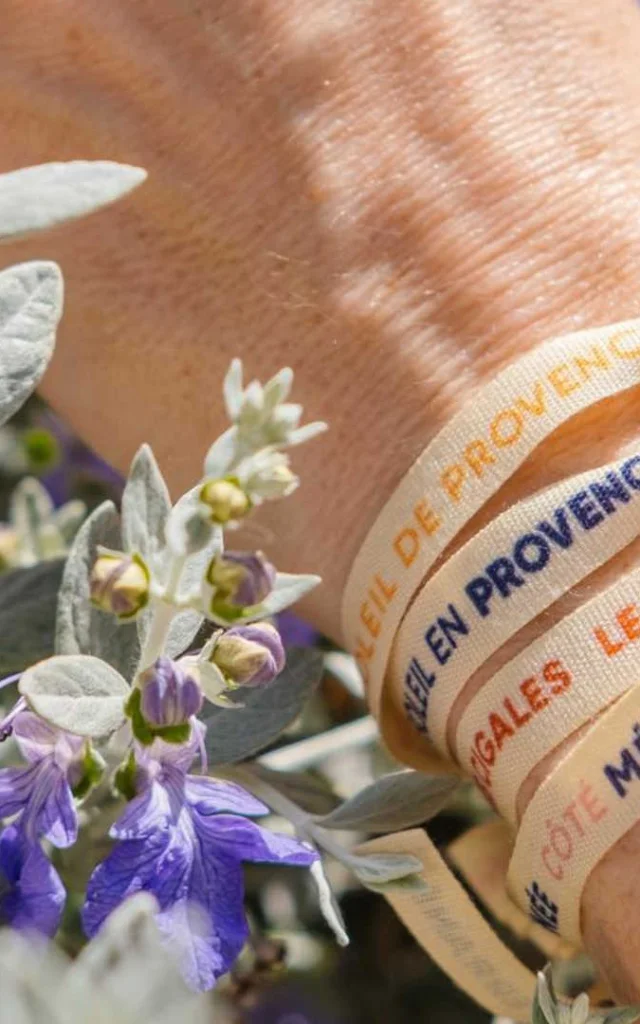 Plusieurs bracelets rubans sur un poignet dans les fleurs