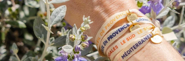 Several ribbon bracelets on a wrist in flowers