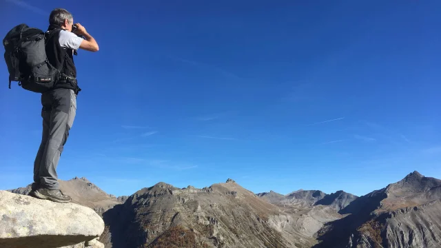 Un randonneur qui observe le panorama du Mercantour avec des jumelles