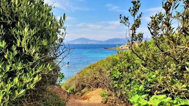 The coastal path at Giens leading to a sea view with a paddle on the water