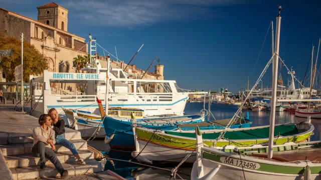 Un couple assis près des pointus du port de La Ciotat