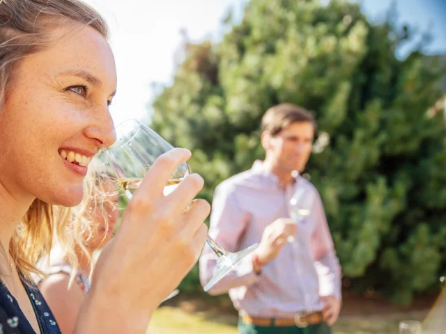 Femme portant un verre de vin blanc à son nez