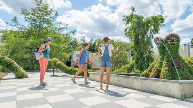 Une mère et ses deux filles regardant la sculpture végétale pieuvre