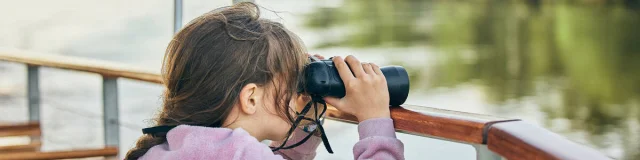 Niña mirando con prismáticos en Loire Odysée