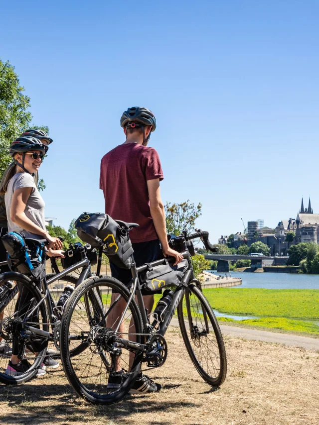 Trois personnes en vélo Gravel en face du château d'Angers