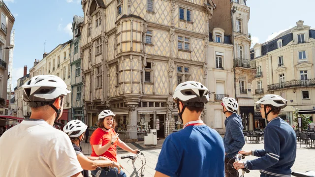 5 personnes à vélo et casque sur la tête sont arrêtées et discutent devant la maison d'Adam