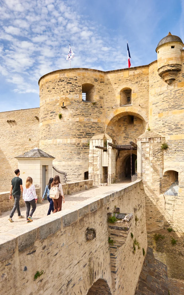 4 personnes entrant dans le château d'Angers, ciel bleu et soleil