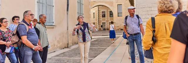 Groupe de seniors écoutant les explications de la guide conférencière dans une rue d'Angers